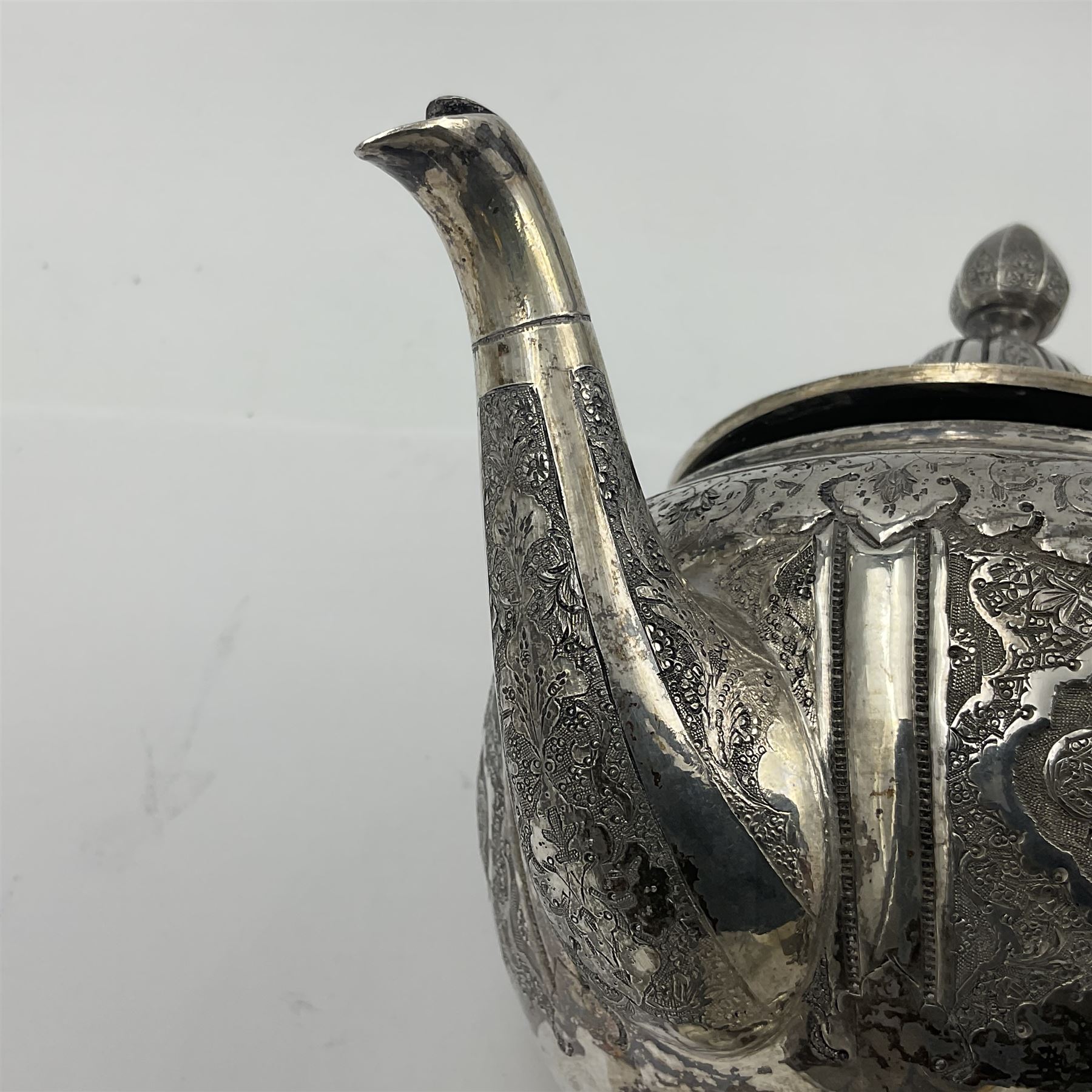 Early/mid 20th century Persian silver tea service, comprising circular serving tray, teapot, twin handled sucrier and cover, milk jug, five tea glasses with six silver holders, six tea spoons, and pair of sugar tongs, each profusely chased with foliate arabesque decoration, each bearing marks including 84 for 840 fineness, tray D40cm, teapot H16cm