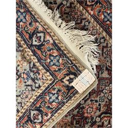 Persian-style wool rug, cream field with floral and geometric motifs, wide floral border (74cm x 142cm); Persian wool rug, beige field with dense floral patterns, narrow floral border (70cm x 144cm); Tribal wool rug, red and navy with diamond motifs (96cm x 60cm); Persian pictorial wool rug, black field with vase, birds, and floral border (70cm x 73cm)