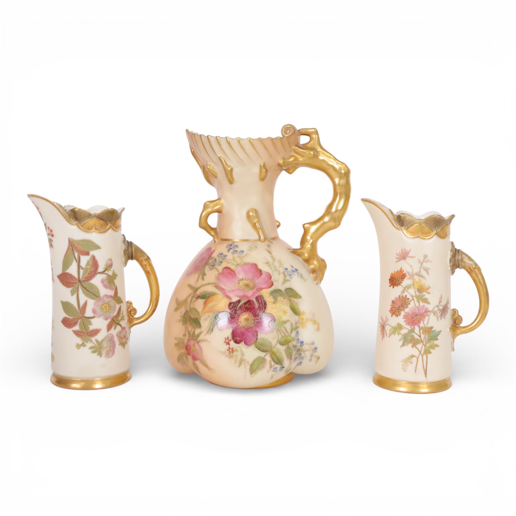 Royal Worcester blush ivory quatrelobe coral jug, decorated with floral sprigs shape 1507 together with two jugs with a shell moulded rim and decorated with flowers, shape 1229, all with puce marks beneath, quatrelobe jug H22cm 