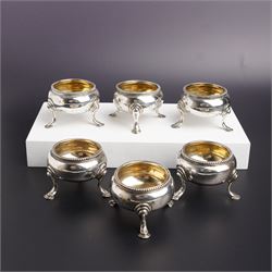 Set of six Victorian silver circular bead edge salts with gilt interiors on shaped support...