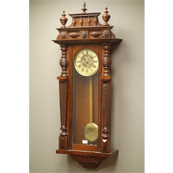  Late Victorian walnut cased Vienna type wall clock, cresting with turned finials, glaed door with fish-scale columns, circular dial with twin train movement striking the half hours on a coil, H115cm   
