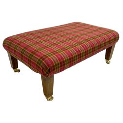 Rectangular footstool, upholstered in checkered fabric, on square tapering supports with brass castors