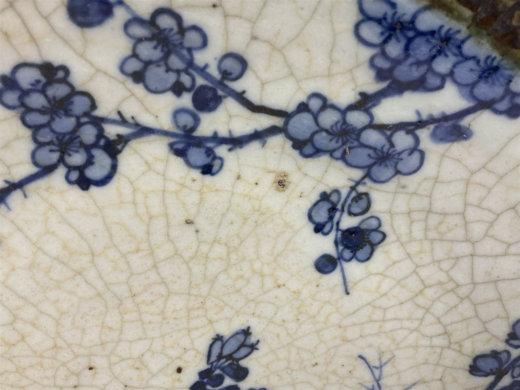 20th century Chinese blue and white crackle glaze charger, decorated with peonies, prunus blossom, and rockwork, within simulated bronze border, with character mark verso, D34cm