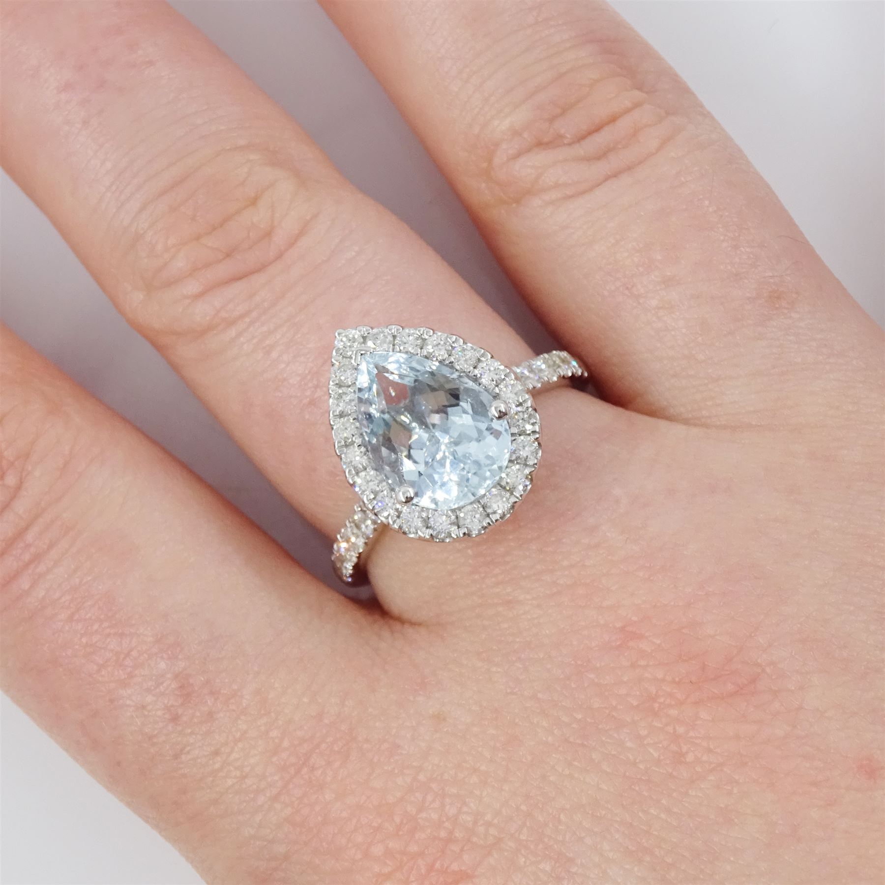 White gold aquamarine and diamond cluster ring, single pear cut aquamarine of approx 2.75 carat, surrounded by round brilliant cut diamonds and diamond set shoulders, hallmarked 9ct
