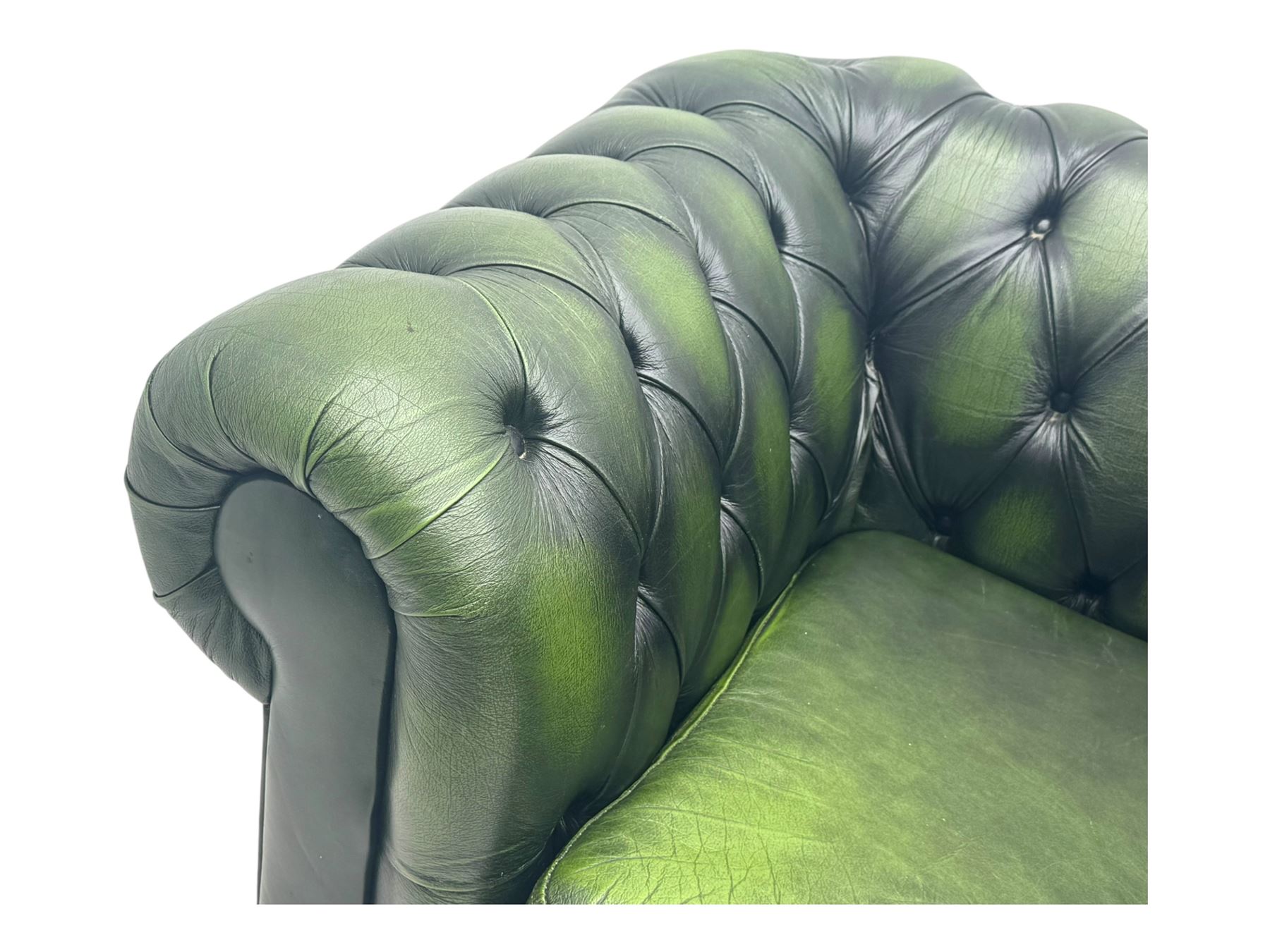 Two seat Chesterfield design sofa bed, upholstered in emerald green leather with deep-buttoned detailing, rolled arms, two loose seat cushions, and pull-out 