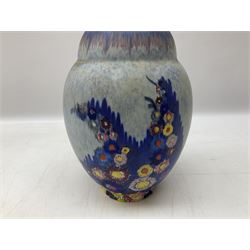 1930s Carlton Ware Art Deco Garden pattern vase of shouldered ovoid form, decorated with blue, pink and yellow flower heads on a mottled blue and white ground, pattern no. 3413, with printed and painted marks beneath, H19cm, together with a Clarice Cliff My Garden pattern vase, raised upon three feet with blue, pink and purple moulded Hollyhock design, H20cm, with Clarice Cliff Wilkinson Ltd England marks beneath