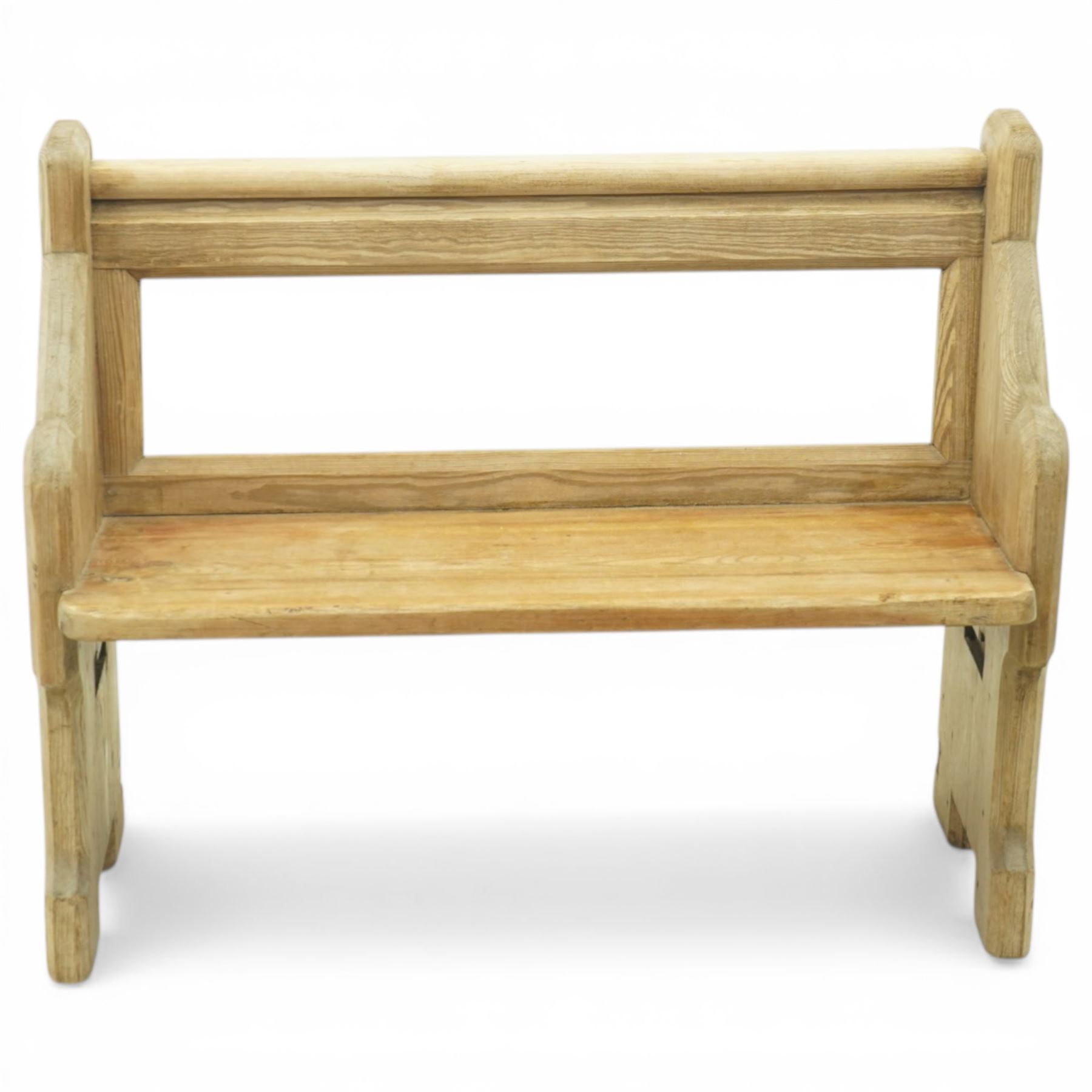 19th century pine pew of small proportions, open rectangular back with panelled frame, rounded top rail and plank seat, shaped slab ends with chamfered detail