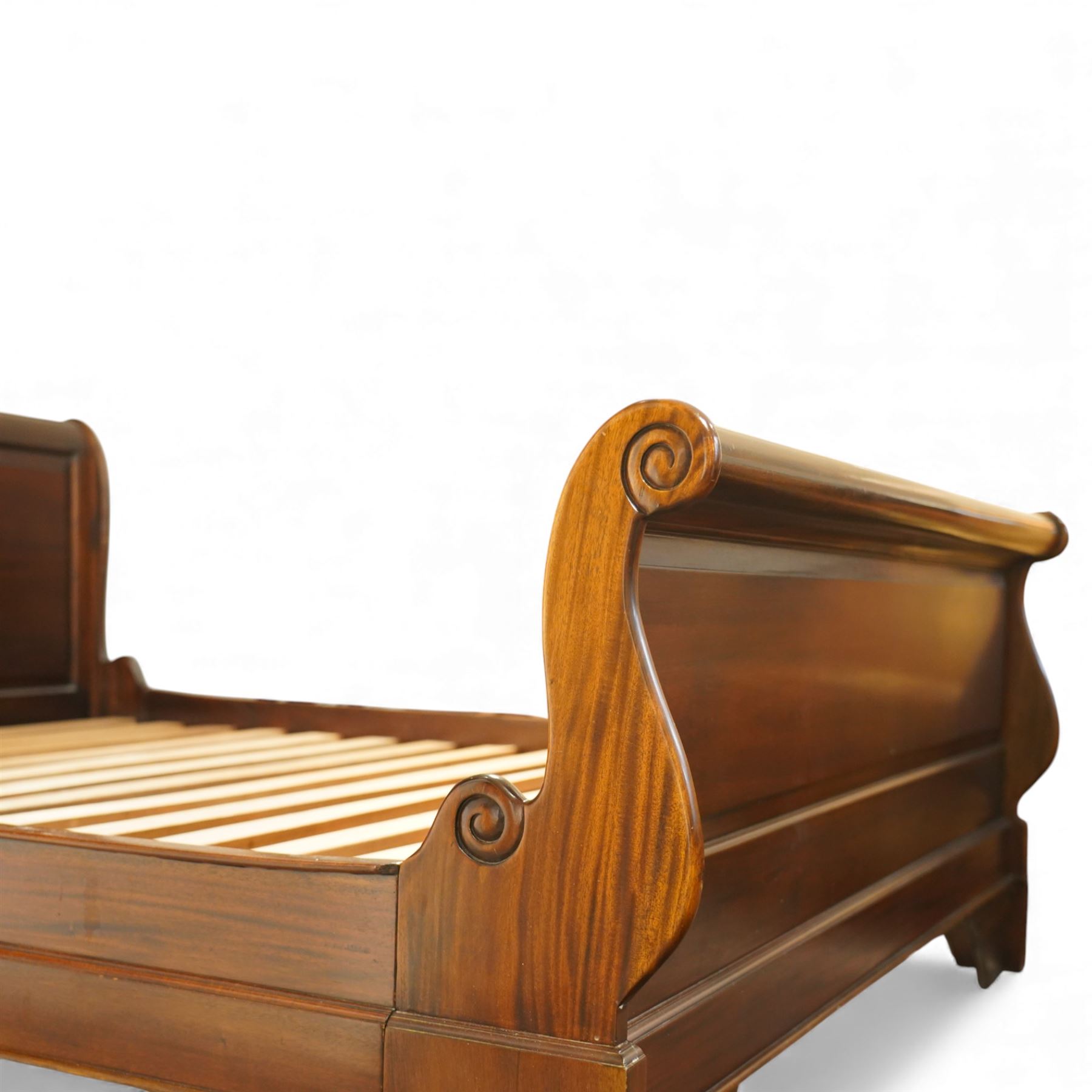 Late 20th century French design mahogany king size sleigh bed, the shaped headboard and footboard with scroll carved terminals and panelled fields, over swept side rails, raised on moulded bracket supports