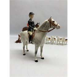 Beswick hunting group, comprising huntswoman on grey horse no 1730, huntsman on brown horse no 1501, two seated fox figures no 1748 and seven fox hounds, all with printed marks beneath (11)