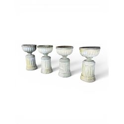 Four 20th century good quality weathered cast stone pedestal urns, circular lobed bowls with rope twist and lattice border, raised on squat base with fluted columns