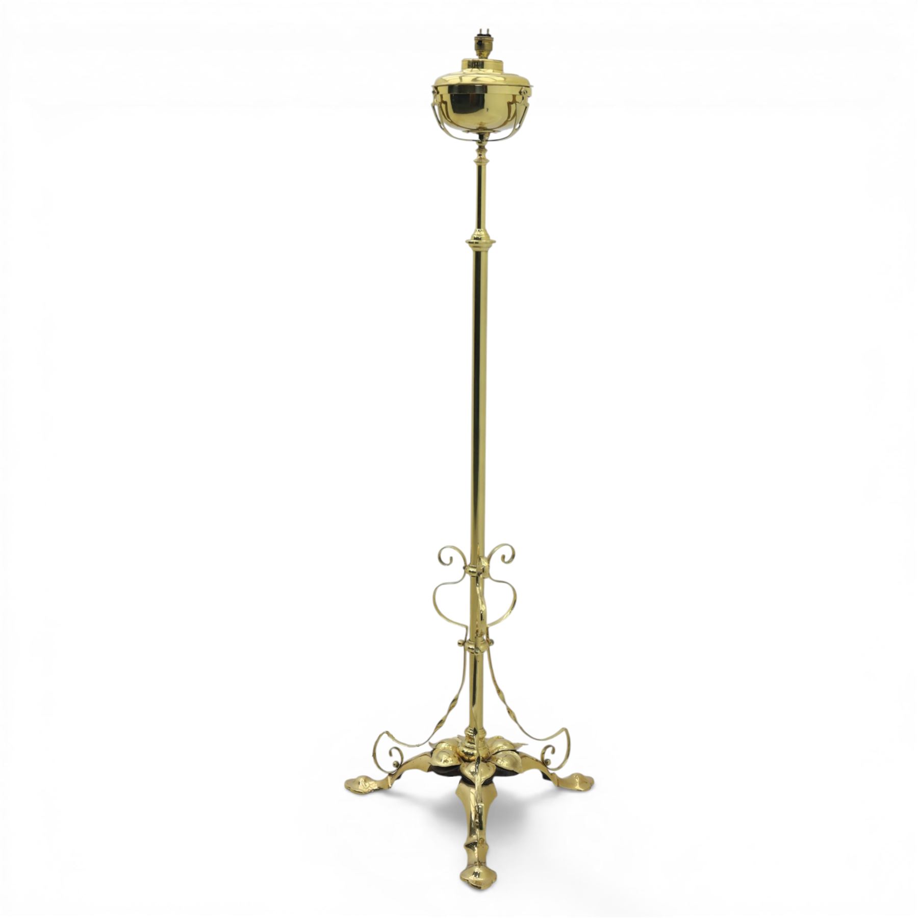 20th century brass standard lamp, urn form reservoir top with hinged cover, on a slender column with knopped detail, the stem fitted with scrolling supports, raised on a triform base with shaped cabriole supports terminating in pad feet