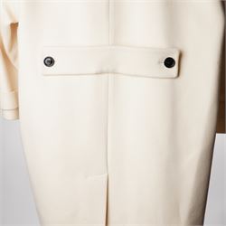 Burberry London - wool coat in cream, with concealed front popper fastening, bracelet-length sleeves with tab and black button detail and side slip pockets, with slit to back, size 40, unused with original Harvey Nichols garment bag and hanger