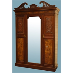  Large Edwardian walnut wardrobe, swan neck pediment with carvings, projecting cornice, two carved and reeded doors flanking centre full length mirror door, enclosing hanging rails and hooks a long and short draw, plinth base, W160cm, H240cm, D57cm  