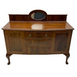 Early 20th century mahogany bow-fronted sideboard, raised back with oval inset mirror, the top with gadroon carved edge, fitted with two cupboards and three drawers, raised on scrolled carved cabriole supports with ball and claw feet