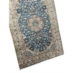 Persian Nain blue and ivory ground rug, wool with silk inlay, overall arabesque design, central medallion surrounded by interlacing and scrolled leafy branches and palmettes, the scrolling border decorated with stylised plant motifs, within guard stripes