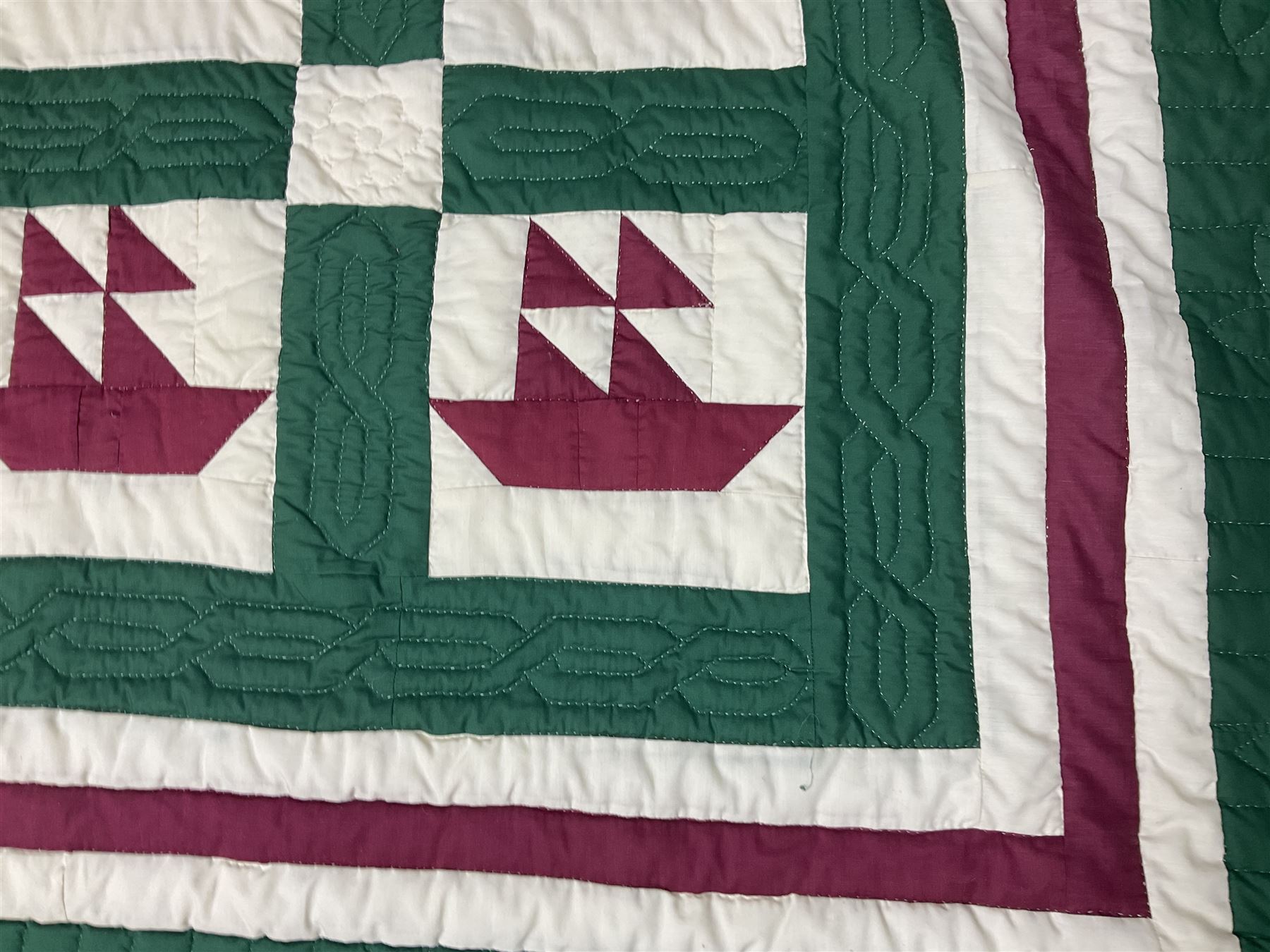 20th century quilt, with repetitive ship design to the centre within a cream red and green boarder, 227cm x 222cm