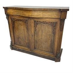 William IV rosewood serpentine chiffonier, fitted with frieze drawer over two panelled cupboard doors with applied C-scroll decoration, flanked by canted uprights with moulded foliate corbels