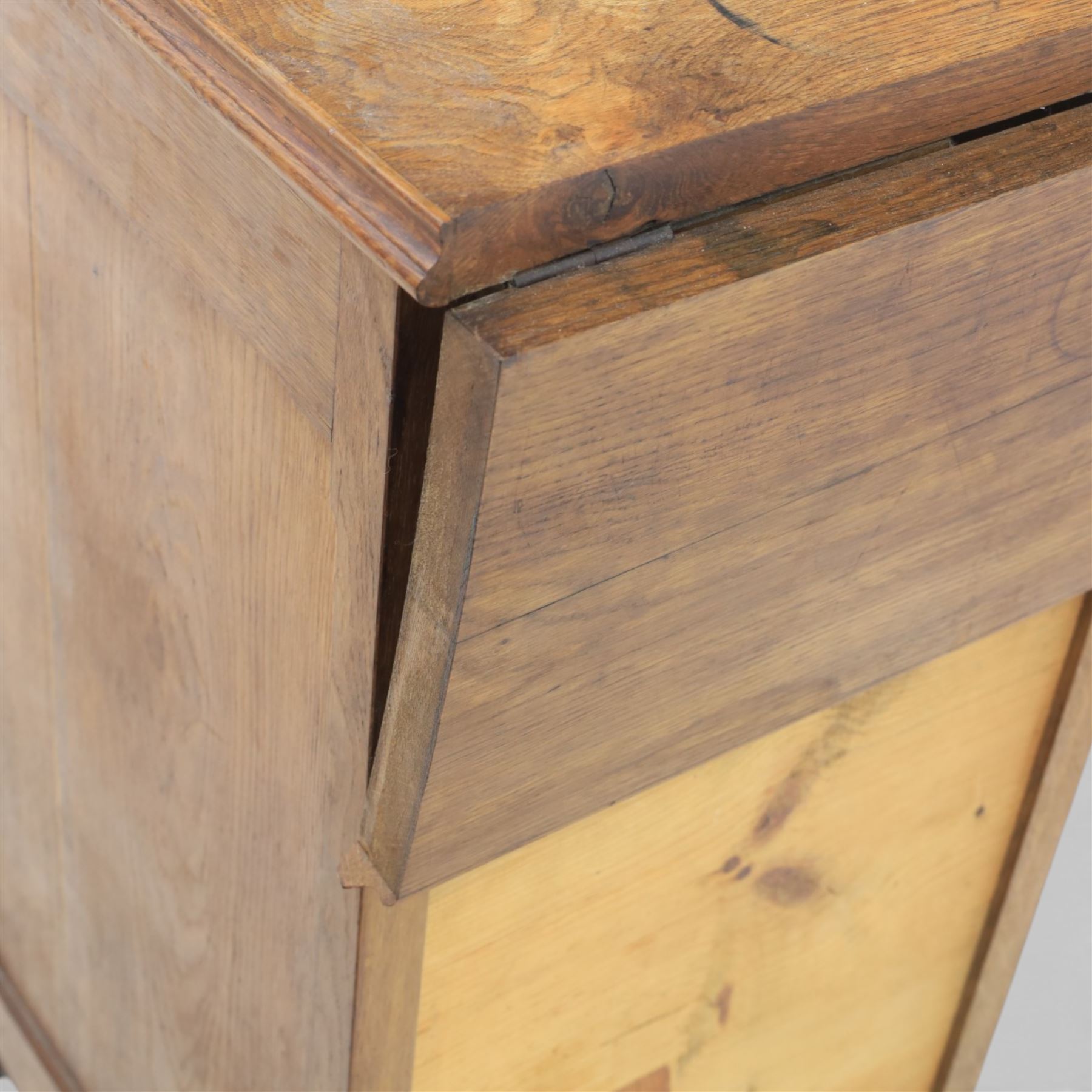 20th century French style oak bedside chest of pedestal form, the top with rounded moulded edge with drop leaf to the back, above five carved drawers with applied scroll ornament and turned knobs, the cupboard base with twin carved doors with diamond lattice panels, with shaped apron and bracket feet