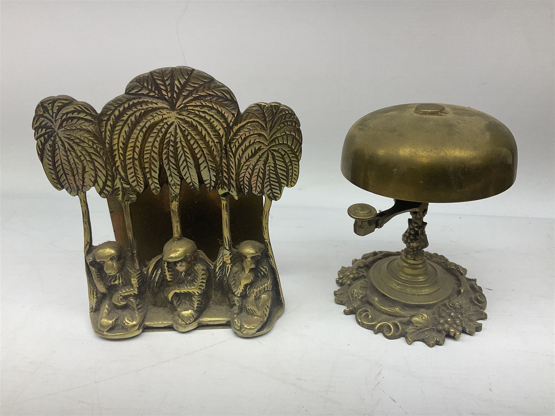 Collection of victorian and later brass desk accessories, to include a letter holder with cherub design, ink well of square form with hinged lid, brass table bell, brass casket with relief decoration, etc  