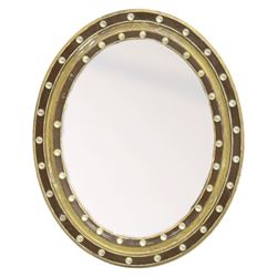Regency design Irish oval wall mirror, circular frame with ebonized slip and two rows of a...