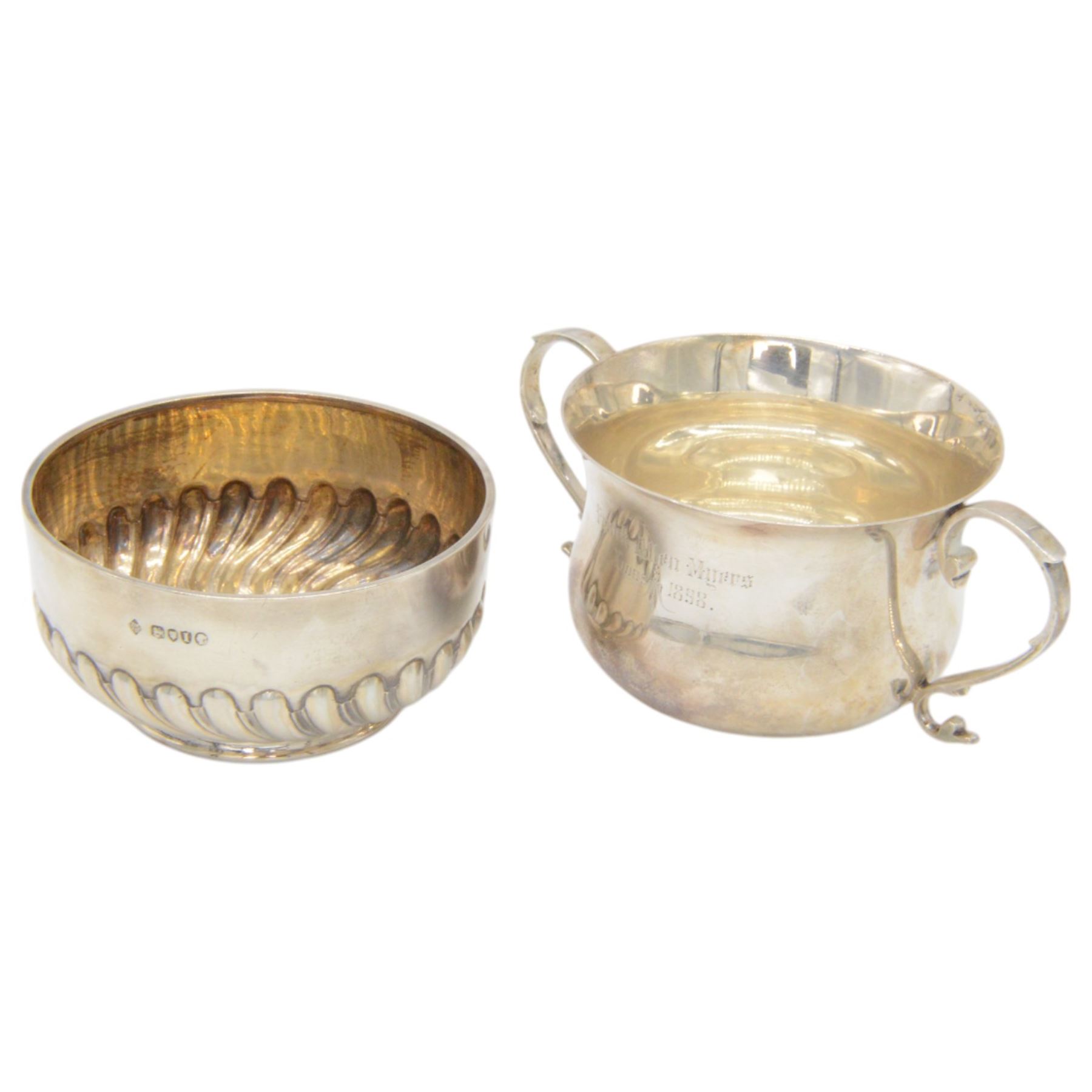 Two Victorian silver Christening sets, the first a twin handled porringer with presentation engraving to body and a matching spoon with rattail bowl, hallmarked Wakely & Wheeler, London 1898, the second example with circular part fluted bowl and matching spoon with twist handle and palmette finial, hallmarked Martin, Hall & Co, London 1884, both contained within tooled leather cases with fitted blue velvet and silk interior