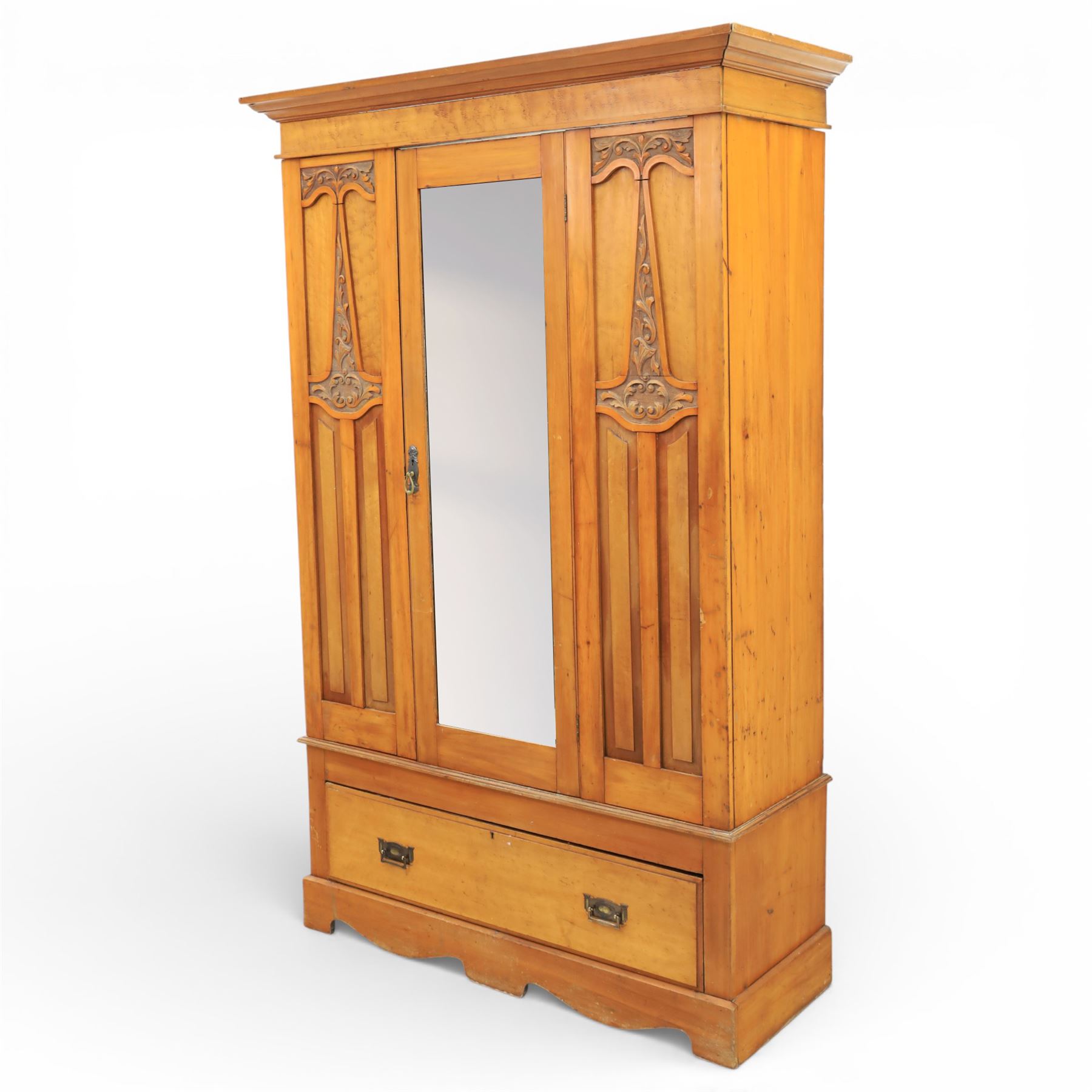 Early 20th century Art Nouveau walnut wardrobe, rectangular top over with single central mirrored panel door, the outer sides carved with sinuous foliate decoration and stylised stem motifs above recessed panels, single long drawer below with brass drop handles, on moulded plinth