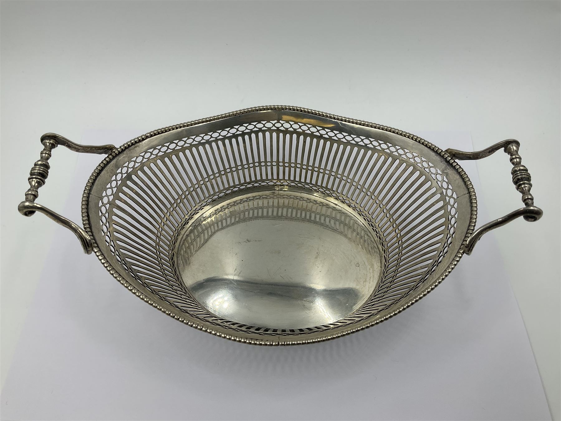 Early 20th century Dutch silver basket, of oval form with pierced sides, beaded rim, and twin handles, marked with Lion Passant for 2nd standard purity and date letter for 1910, other marks worn and indistinct, including handles H8.5cm L25.5cm