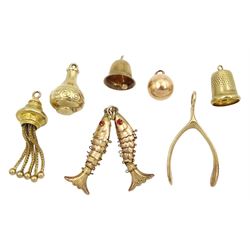 Six 9ct gold pendant/charms including wishbone, thimble, tassel and bell and a gold-plated articulated double fish pendant/charm