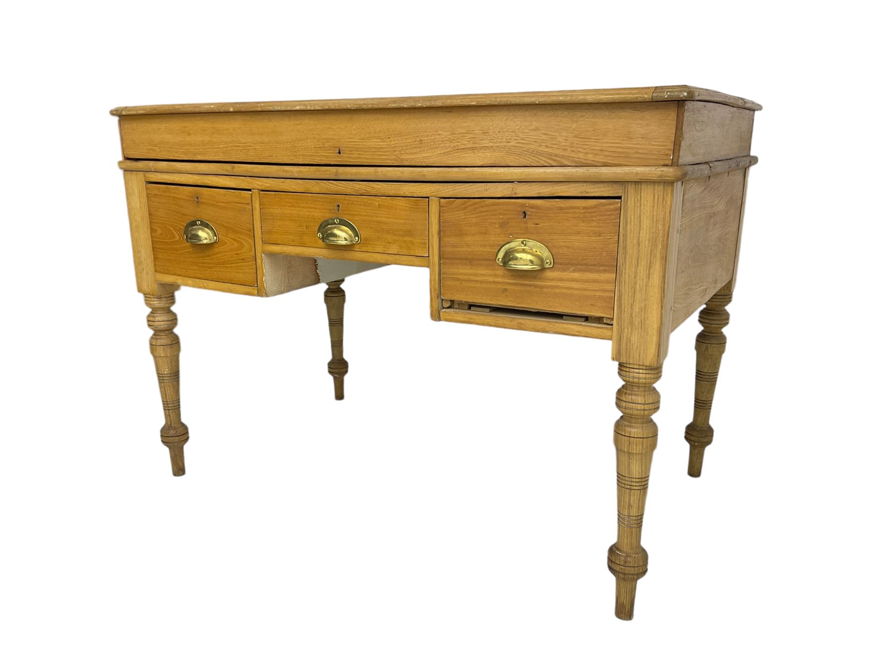 Early 20th century light oak kneehole desk, rectangular hinged top, fitted with frieze drawer flanked by two deep drawers, raised on ring turned supports
