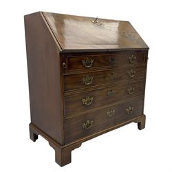 George III mahogany bureau, fall-front enclosing a fitted interior of drawers, pigeonholes and central mirrored cupboard, over four graduated cockbeaded drawers with brass batwing handles, raised on bracket feet