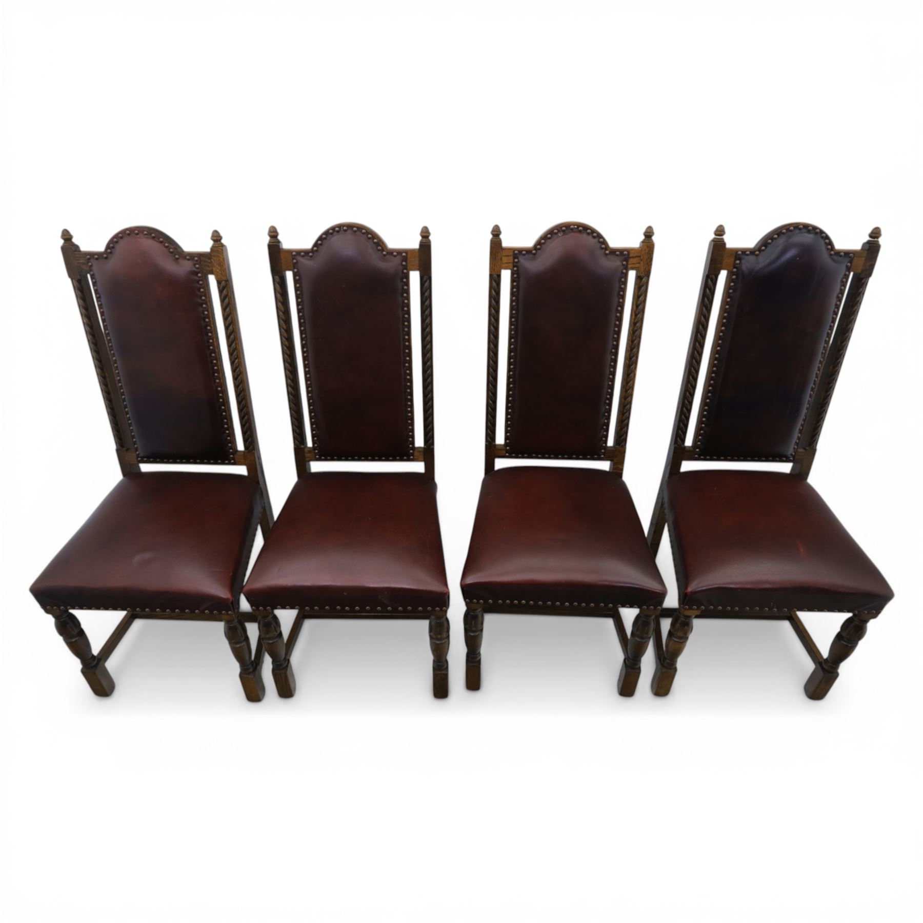 Carolean revival oak dining table and eight chairs (7+1), refectory table with rectangular boarded top and cleated ends, raised on shaped trestle end supports with central stretcher, accompanied by eight high-back chairs including a carver, leather upholstered panels and seats with studwork, on turned legs with stretchers.