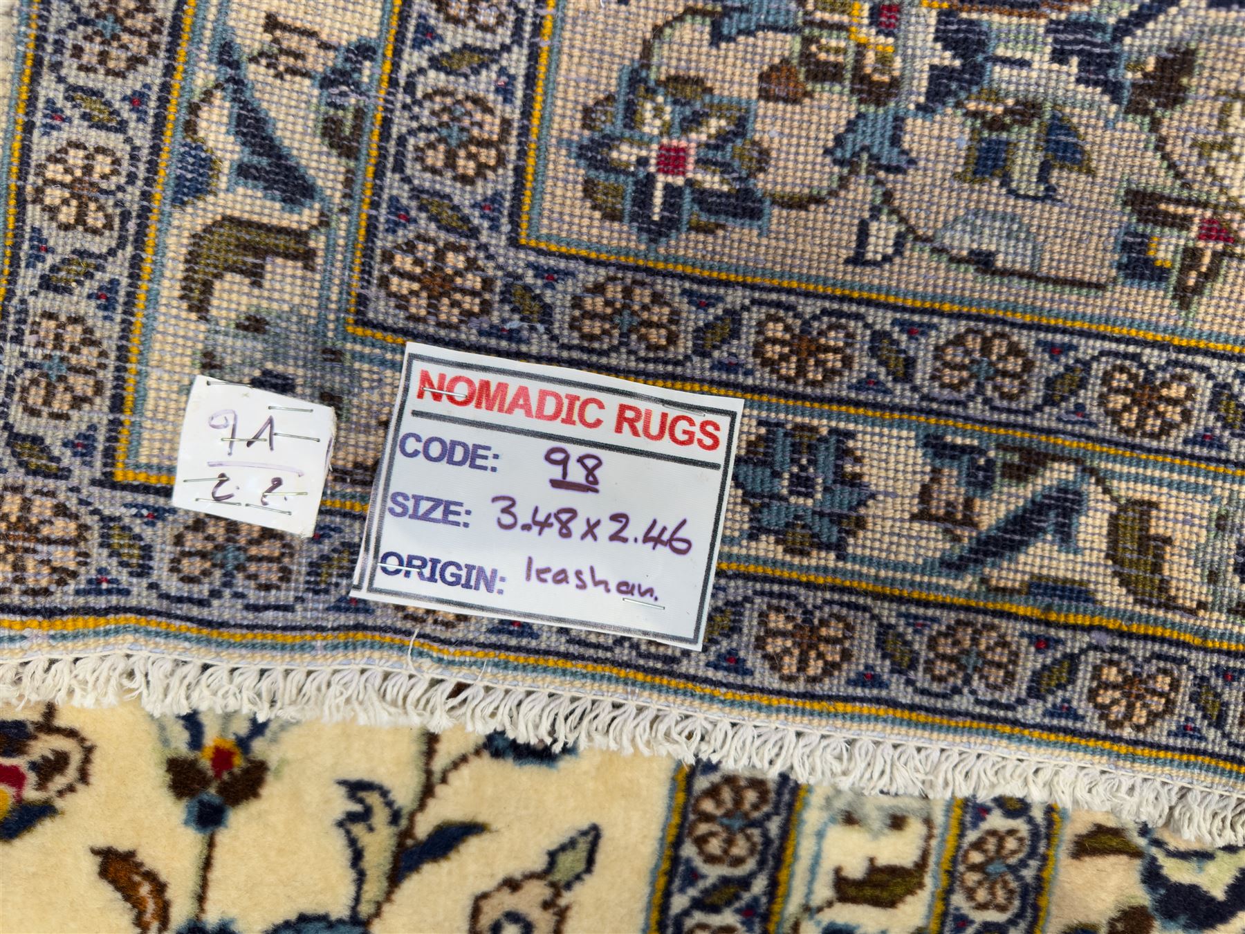 Central Persian Kashan hand-knotted carpet, ivory field with an all-over design of scrolling vines, lotus palmettes, and rosettes in shades of blue and brown within a blue ground border of palmettes and arabesques between multiple guard stripes, 
348 cm x 246cm