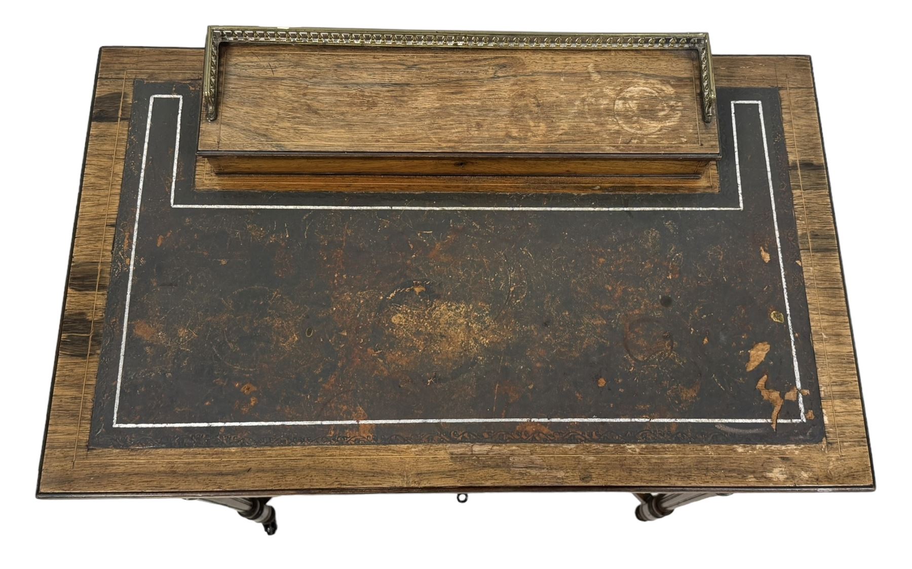 Late Victorian walnut writing table, rectangular leather-inset top surmounted by a brass gallery, fitted with a single frieze drawer, raised on turned tapering supports with lower undertier and ceramic castors