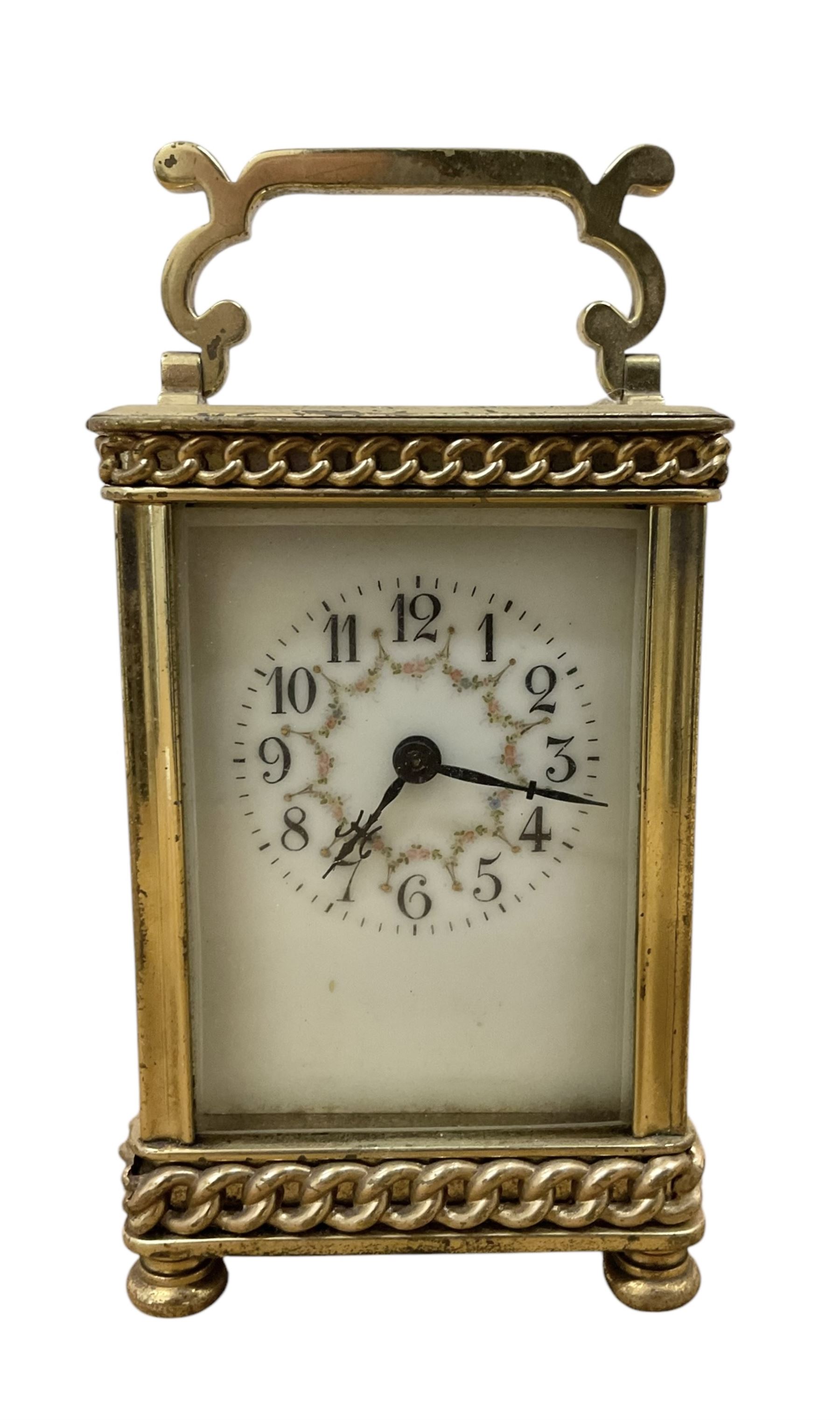 French- Edwardian 8-day carriage clock c1910, with recessed chain decoration and a serpentine handle, four recessed glass panels raised on bun feet, decorative enamel dial with floral swags, Arabic numerals and matching steel hands, single train movement with a cylinder platform escapement. With key.