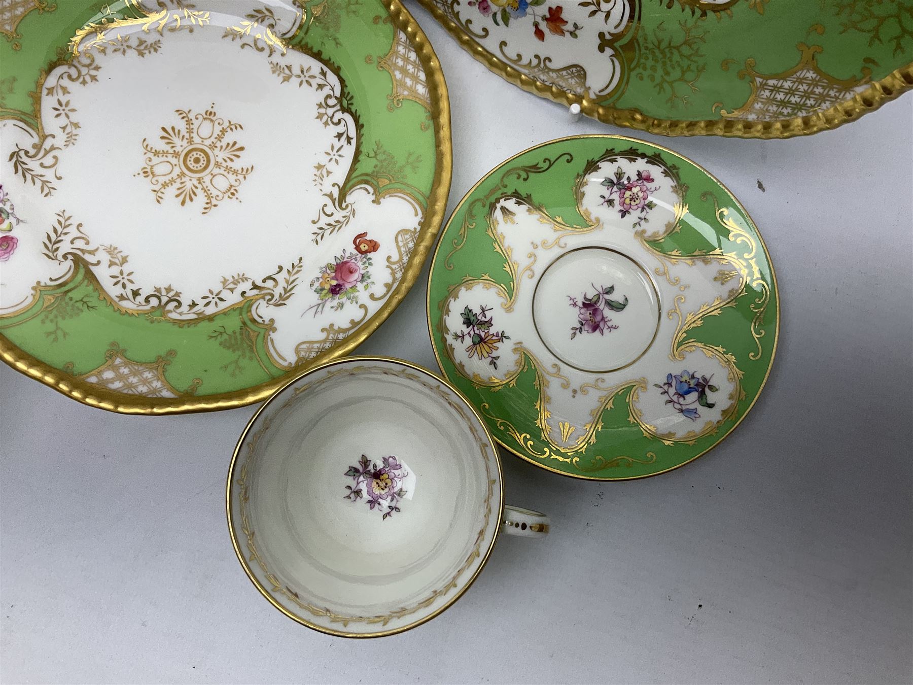 Coalport green batwing pattern tea wares, decorated with finely enamelled floral sprays within gilt reserves, comprising teacup trio, twin handled cake plate and side plate, pattern no Y2665, together with a Coalport for Harrods cup and saucer similarly decorated, the saucer with stamped mark beneath 'Manufactured for Harrods Ltd, Brompton Rd London', all with green Coalport AD 1750 marks beneath, largest W31cm (7)