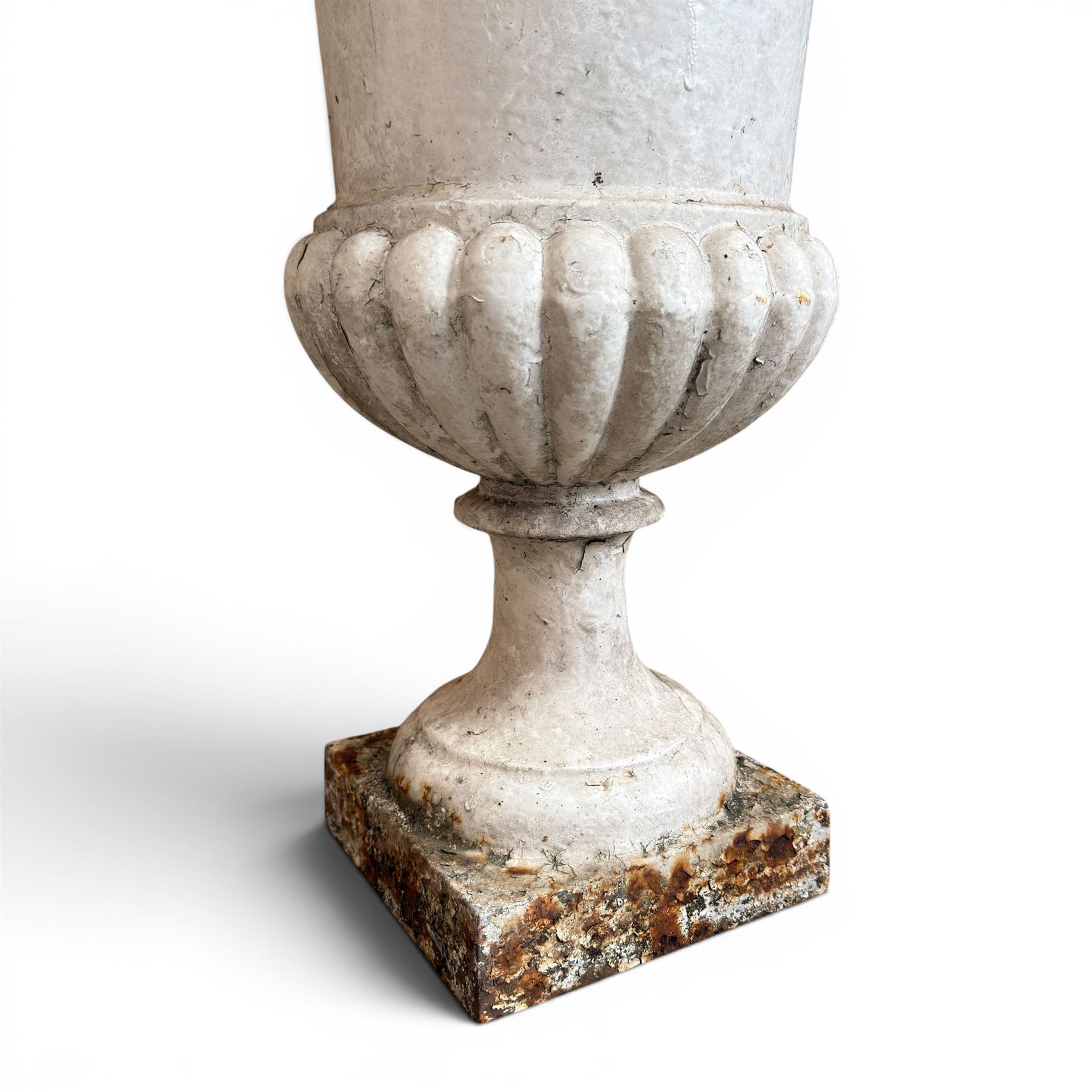 Pair of Victorian revival cast iron garden urns, egg and dart rim, tapering column with gadrooned waist, on square base, finished in distressed white paint