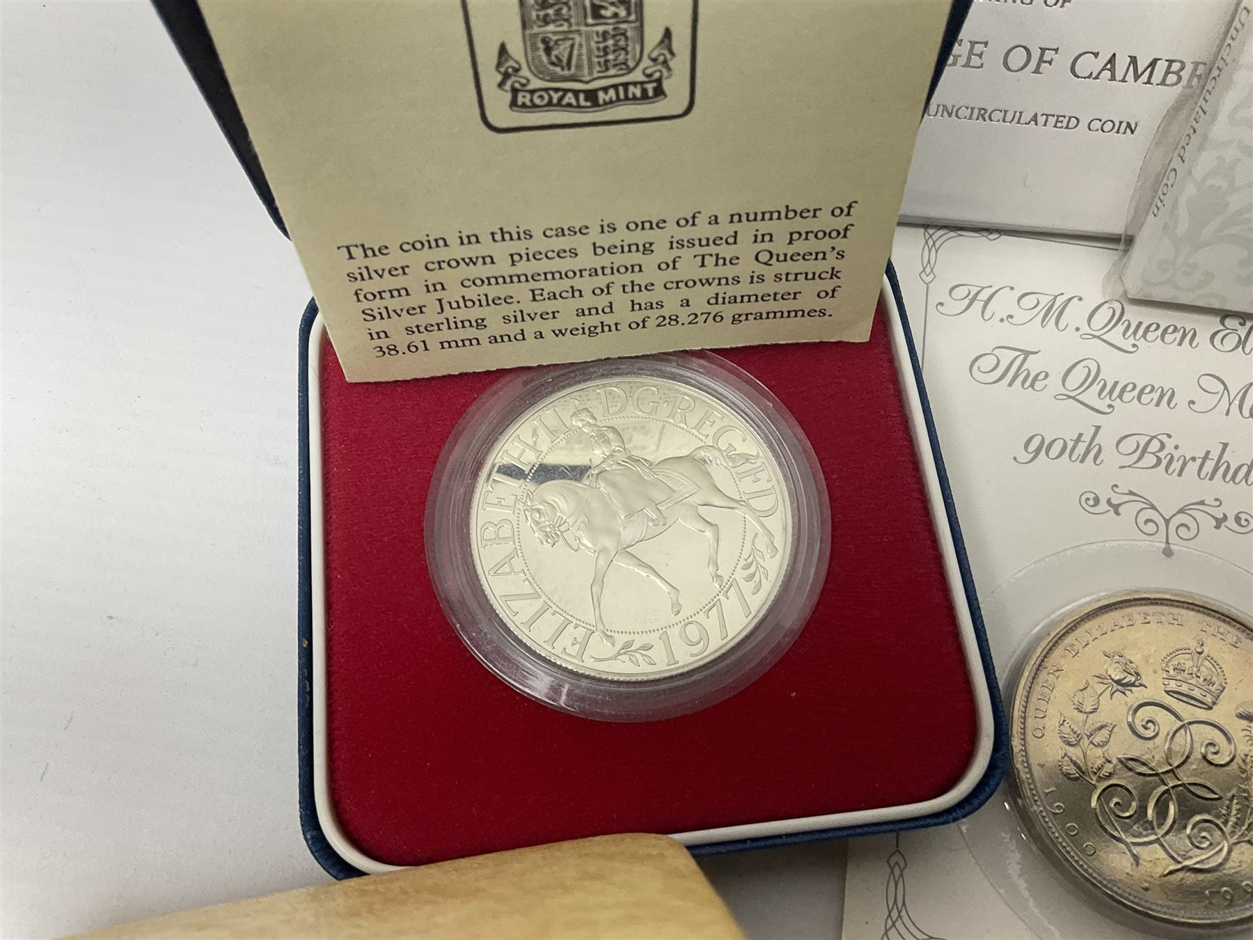 Queen Elizabeth II 1977 silver crown and 1980 silver crown, both cased with certificates, Bailiwick of Guernsey 1978 silver crown cased without certificate, three United Kingdom brilliant uncirculated five pound coins in card folders and twelve other five pound coins