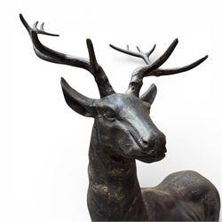 Pair of life-size cast iron garden or home stags, modelled standing upon oval plinths