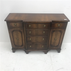 Small reproduction cross banded mahogany breakfront cabinet, two short and four long drawers, two cupboards, shaped bracket supports, W105cm, H77cm, D36cm