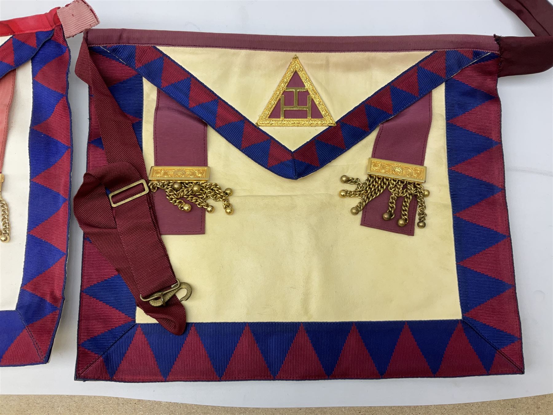 Two Masonic kid leather aprons, one with sash and cuffs, the other with sash, each marked 'Yorkshire North and East Ridings'; and three other unmarked Masonic aprons with sashes
