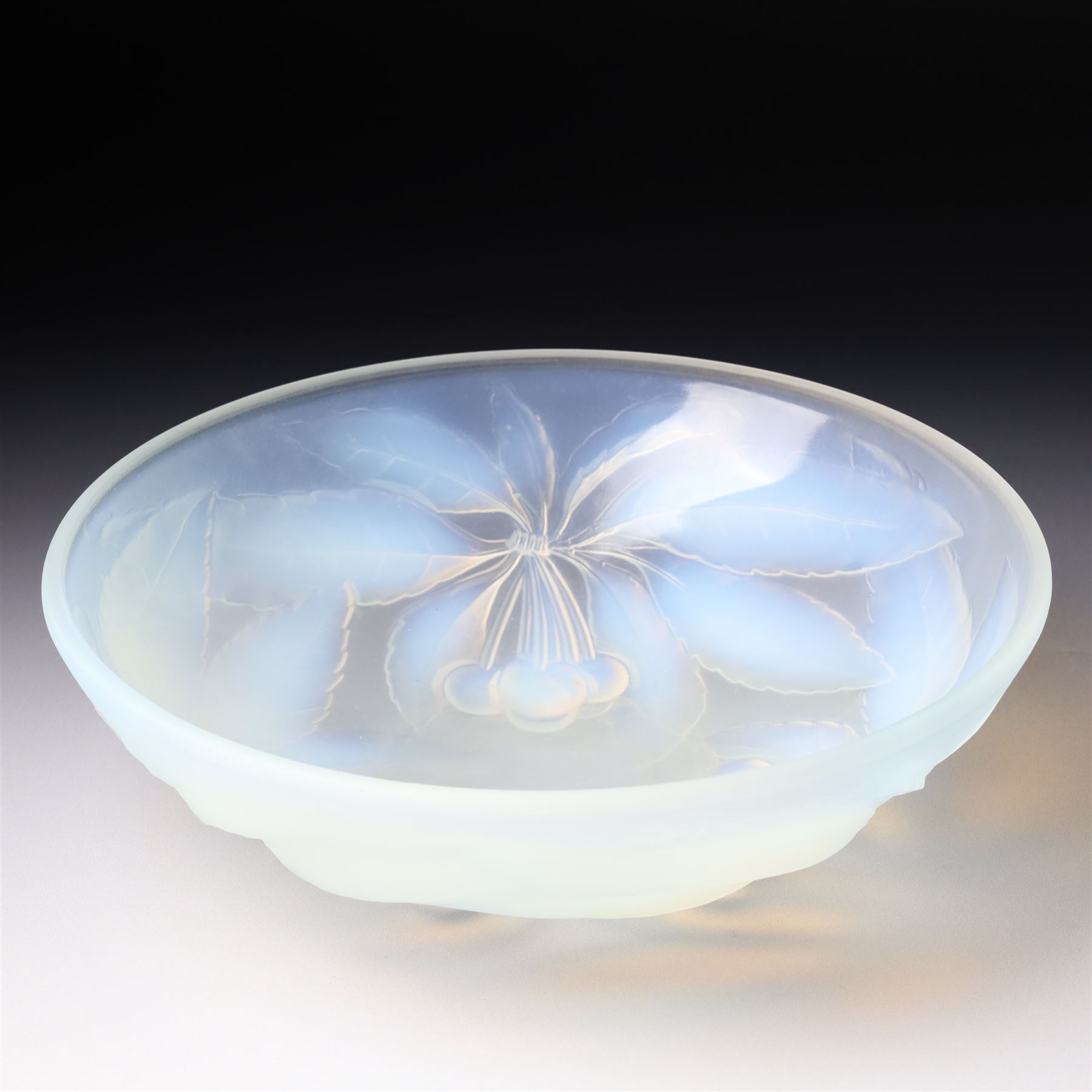 G Vallon, a French opalescent glass bowl decorated with a raised pattern of cherries and leaves signed G Vallon D23cm