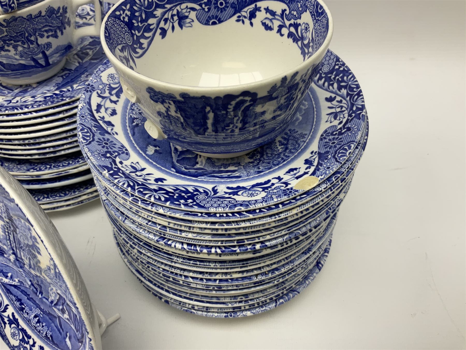 Spode blue and white Italian pattern dinner and tea wares, comprising five dinner plates, four side plates, seventeen side plates, four bowls, ten tea cups and twenty one saucers, five coffee cans and six saucers, and a flan dish, with blue and black printed marks beneath 
