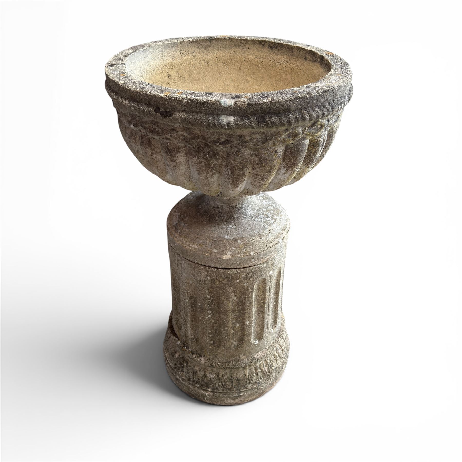 20th century good quality weathered cast stone pedestal urn of ecclesiastical design, circular lobed bowl with rope twist and lattice border, raised on squat base with fluted column  and acanthus decorated base