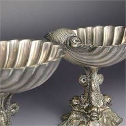 Pair of Victorian silver plated comports, with clam shell bowls supported by three dolphins upon a rocky base, H12cm