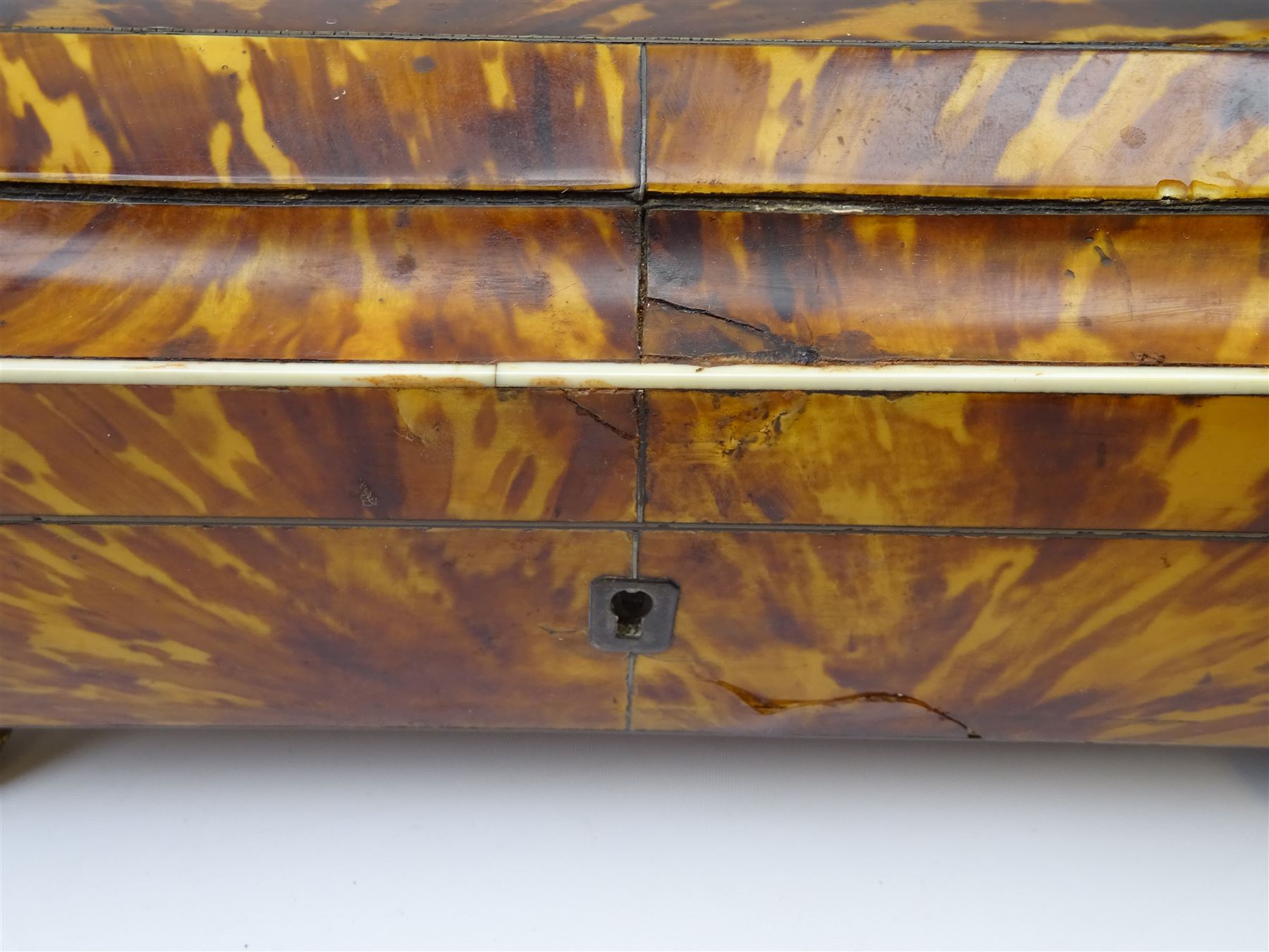 19th century tortoiseshell sewing box, of sarcophagal form upon four foliate detailed brass ball feet, the hinged cover edged in ivory with initialled silver plaque to centre, opening to reveal a silk lined interior, H9.5cm W22.5cm D18cm
