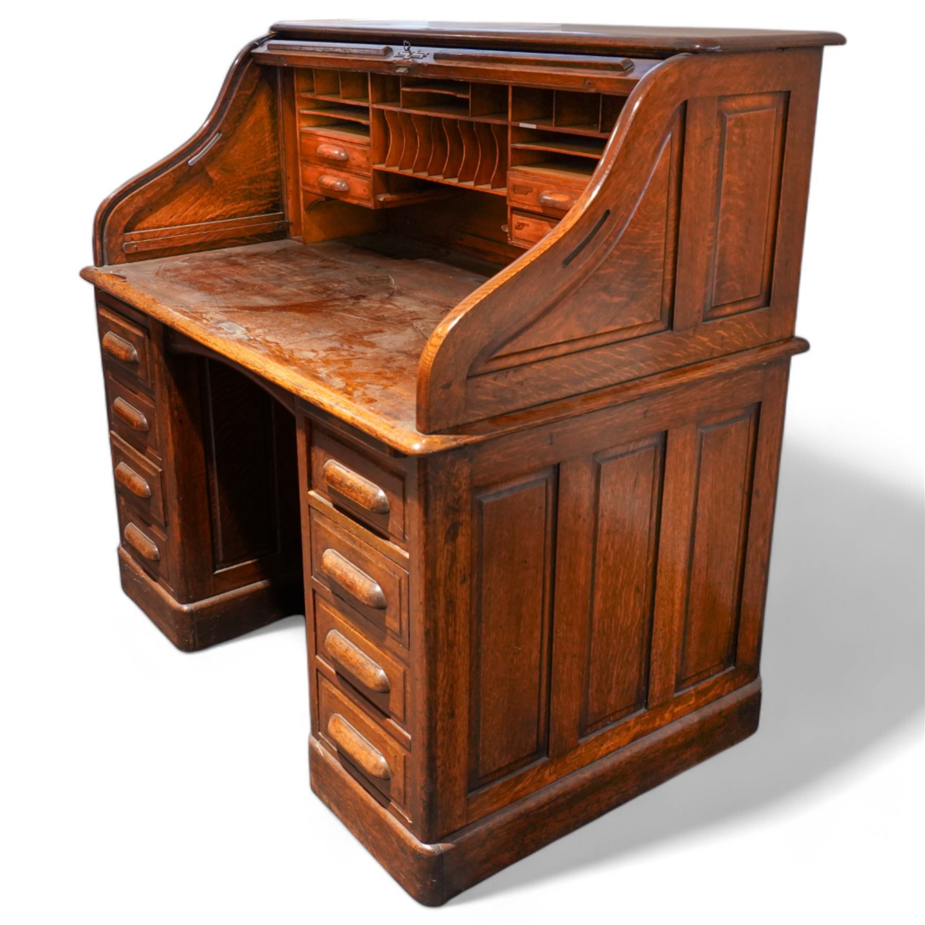 Early 20th century oak twin pedestal roll top desk, tambour roll enclosing small drawers and pigeon holes, fitted with seven drawers, on plinth base 