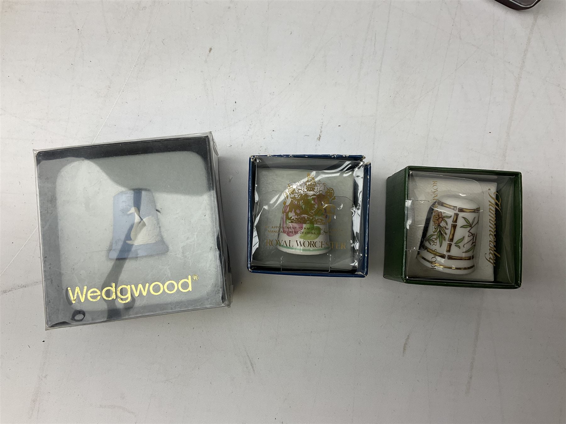 Quantity of thimbles to include twelve Irish Dresden lace examples, Royal Crown Derby, Spode, Portmeirion, Wedgwood, Royal Grafton etc, together with three display cases, many with certificates