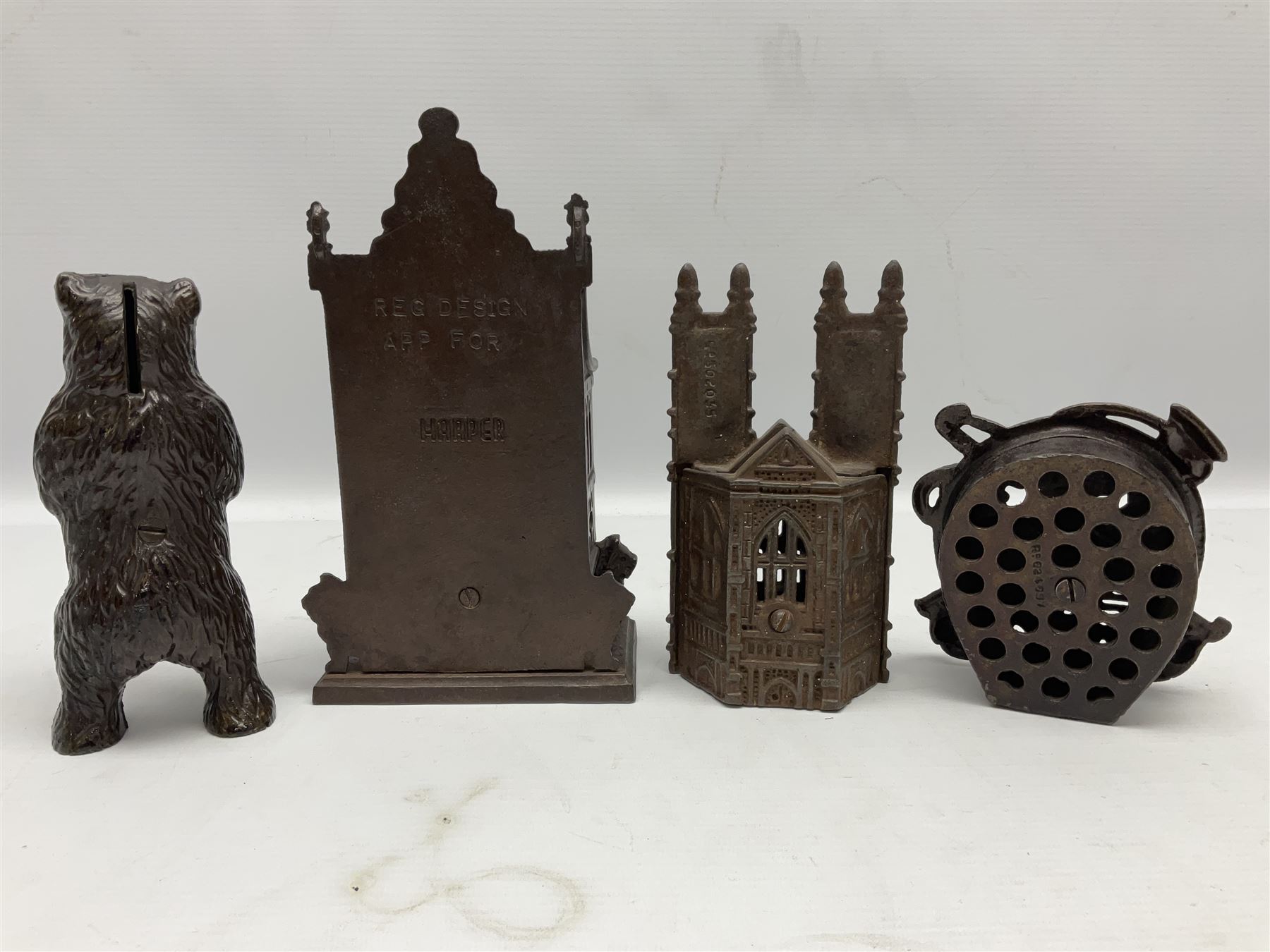 Four cast-iron money banks - 'Bear On Hind Legs bank' c1906 H16cm; 'ERII English Throne Bank' 1953 H21cm; both made by John Harper; 'Tally-Ho Bank' c1906 by Chamberlain & Hill H11.5cm; and 'Westminster Abbey Bank' c1908 by Sydenham & McCoustra H16cm (4)