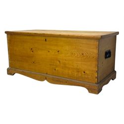 Late 19th century stripped pine blanket box, rectangular hinged lid enclosing main compartment with fitted candle box, wrought iron strap hinges and lock, black-painted side handles, on a shaped plinth base