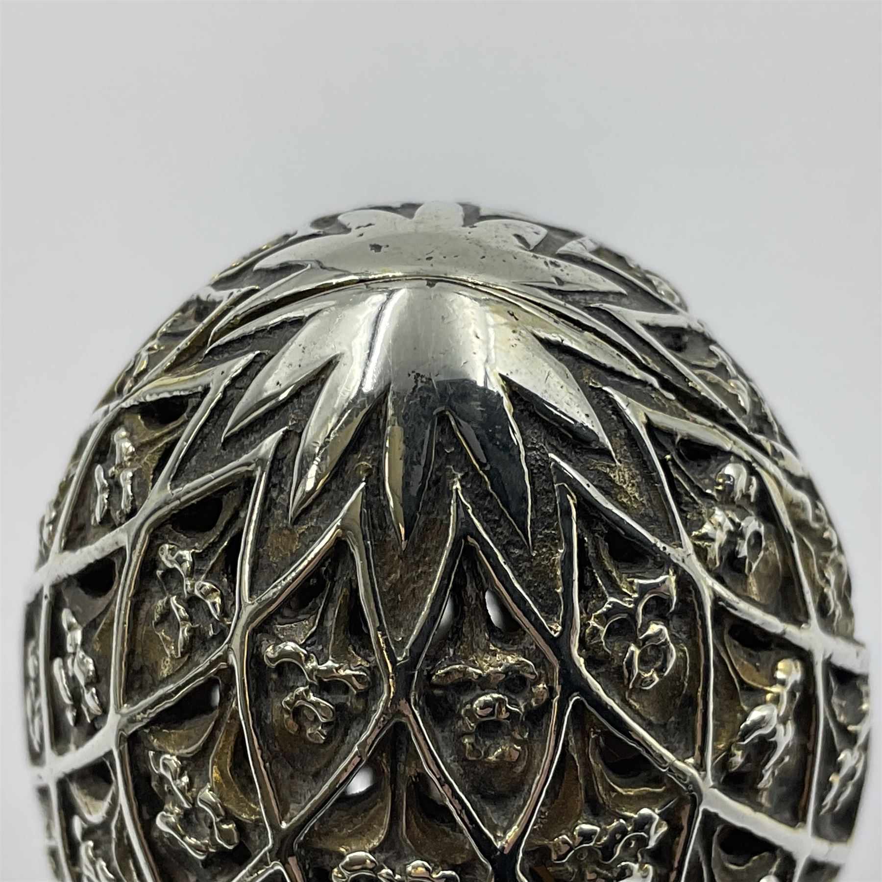 Modern silver limited edition Easter egg, no. 70/500, the openwork lattice body decorated with gilded panels of flower heads, opening to reveal a gilt interior, upon silver stand with three scrolling pad feet, each hallmarked St James House Company, London 1979, height including stand 8cm